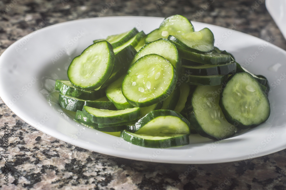 Cucumber pickles on a white plate with dark background and copy space. Cucumber pickles on a white plate with dark background and copy space.