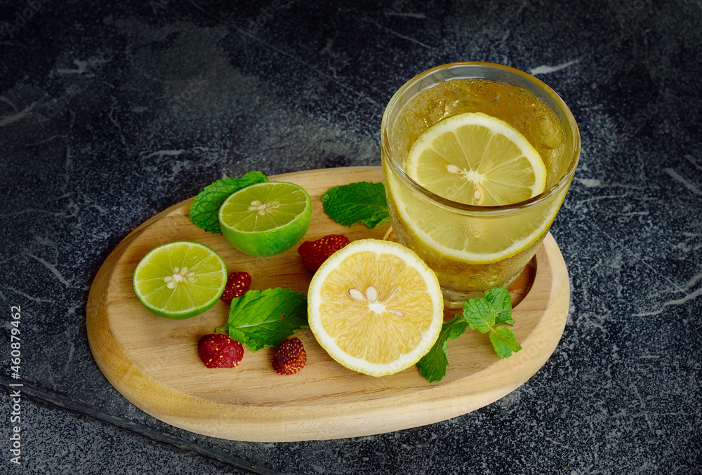 Cold fresh lemon juice with lemon sliced on wooden tray Cold fresh lemon juice with lemon sliced on wooden tray