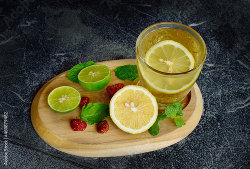 Cold fresh lemon juice with lemon sliced on wooden tray © chuanthit