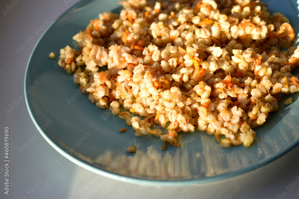 Boiled pearl barley with spices on a plate Boiled pearl barley with spices on a plate