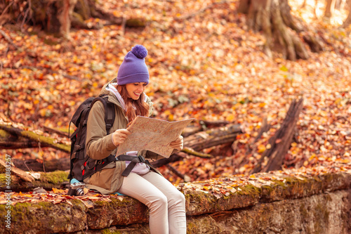 Woman reading a map while hiking through the forest