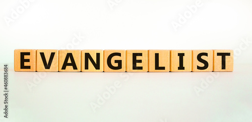 Evangelist symbol. The word Evangelist on wooden cubes. Beautiful white table, white background. Business and evangelist concept. Copy space.