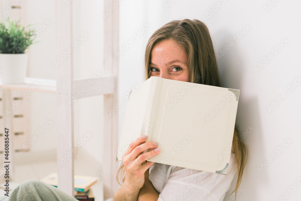 Girl covers her face with book. Literature, reading and knowledge concept. Girl covers her face with book. Literature, reading and knowledge concept.