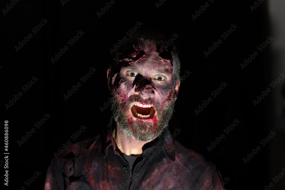 Zombie man portrait in darkness with makeup for halloween party Zombie man portrait in darkness with makeup for halloween party