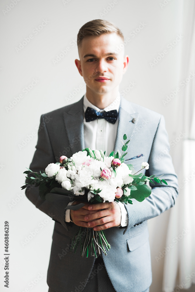 Happy handsome smiling groom posing with boutonniere Happy handsome smiling groom posing with boutonniere