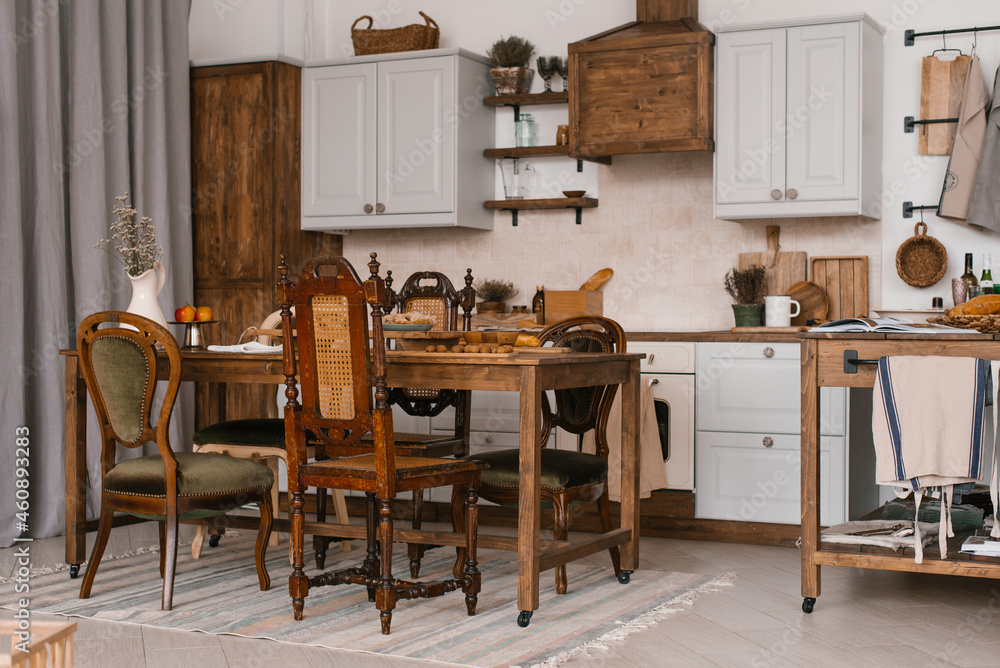 Kitchen table with food and kitchenware with a variety of wooden chairs in the Scandinavian style