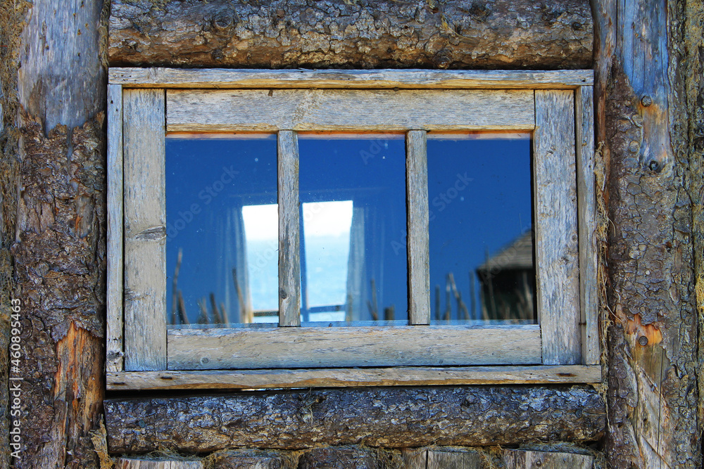 Looking in through an old, wood framed window in the wall of a log cabin, and out through the window on the opposite wall, at the Atlantic Ocean. Looking in through an old, wood framed window in the wall of a log cabin, and out through the window on the opposite wall, at the Atlantic Ocean.