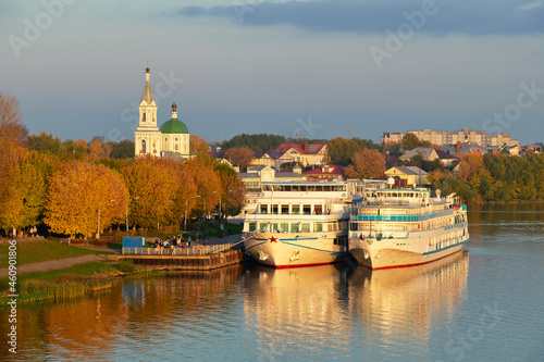 Beautiful city Tver landscape view of orange sunset, docked ships on river Volga and Catherine's convent with sky, green trees and old russian buildings. Tver, Russia.