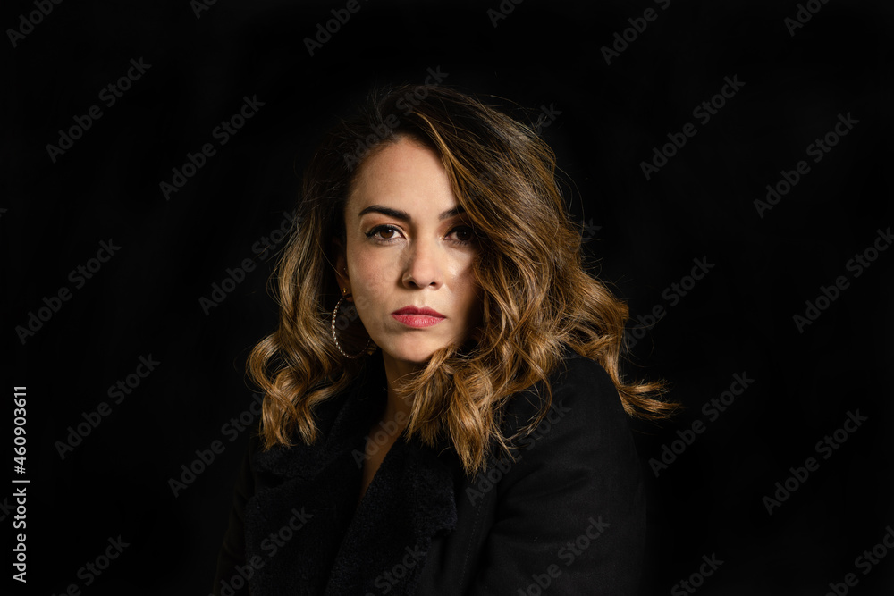 Portrait of young woman with proud and arrogant expression. Confident and proud of herself woman on black background