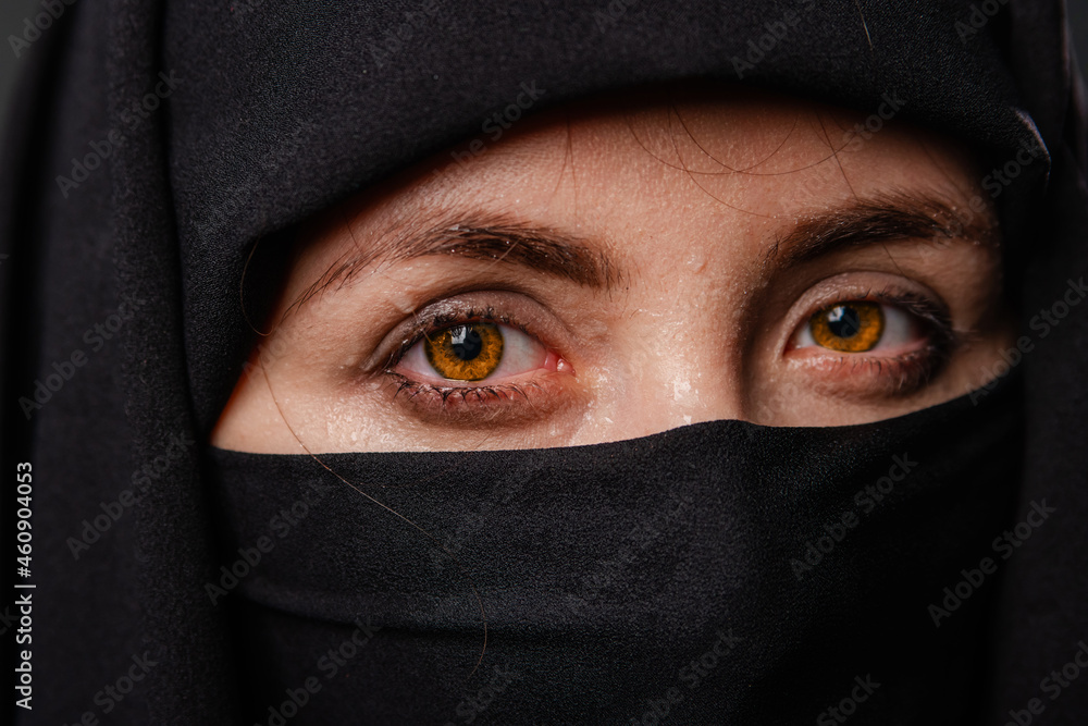 Close up portrait of young, adult woman in black burqa with hidden face, isolated on black background. Close up portrait of young, adult woman in black burqa with hidden face, isolated on black background.