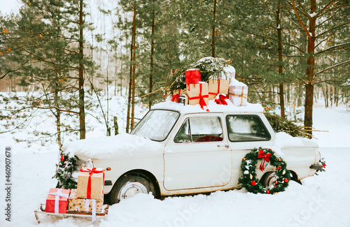 retro car decorated for Christmas with gifts among the winter forest, concept of Christmas, New Year celebration and winter holidays