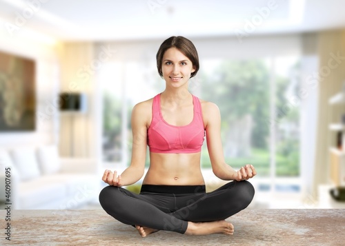 The girl does yoga, woman at home practices asanas. Hands on chest, mudra.