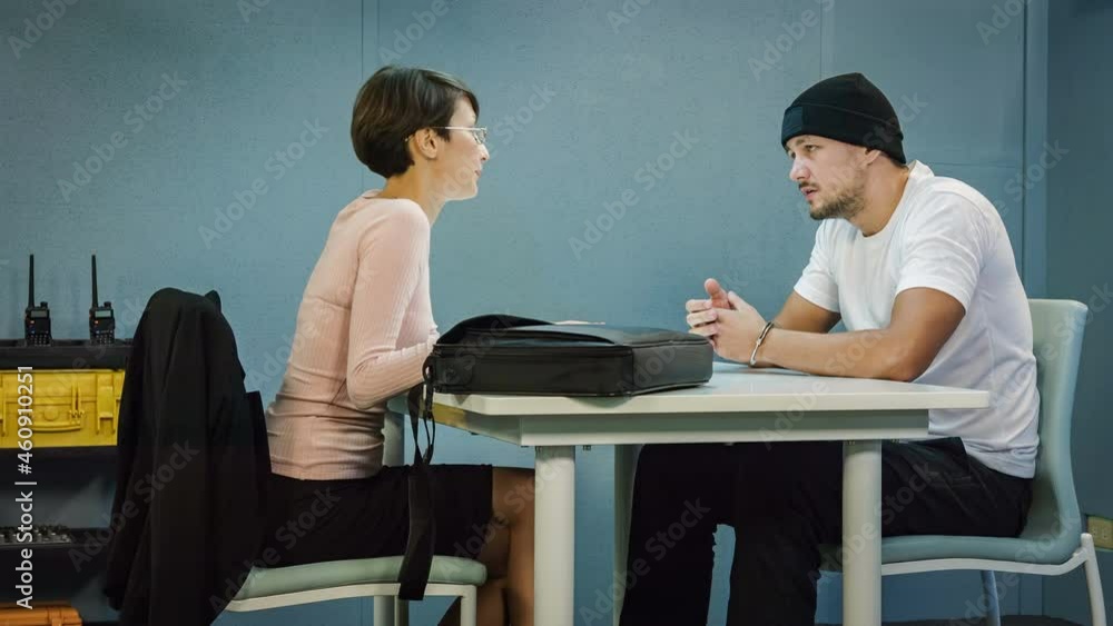Criminal defendant with lawyer speaking about lawsuit in the interrogation room Criminal defendant with lawyer speaking about lawsuit in the interrogation room