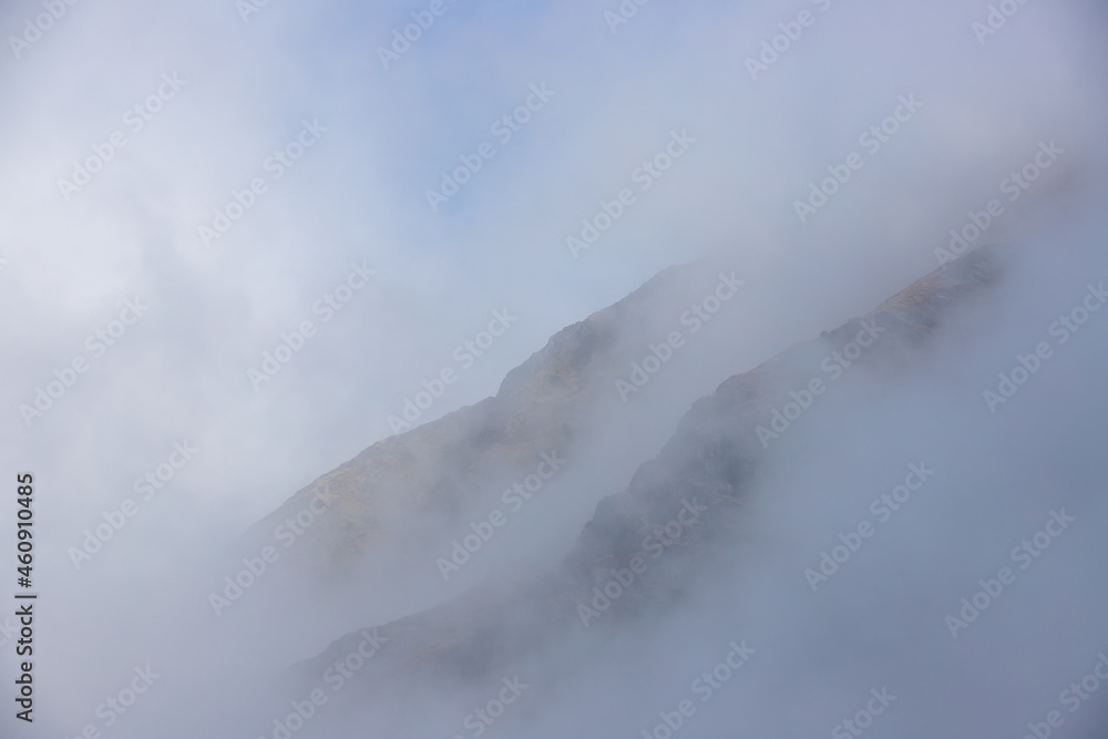 landscape with the silhouette of the slopes of a mountain in the fog