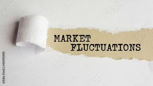 MARKET FLUCTUATIONS. words. text on gray paper on torn paper background