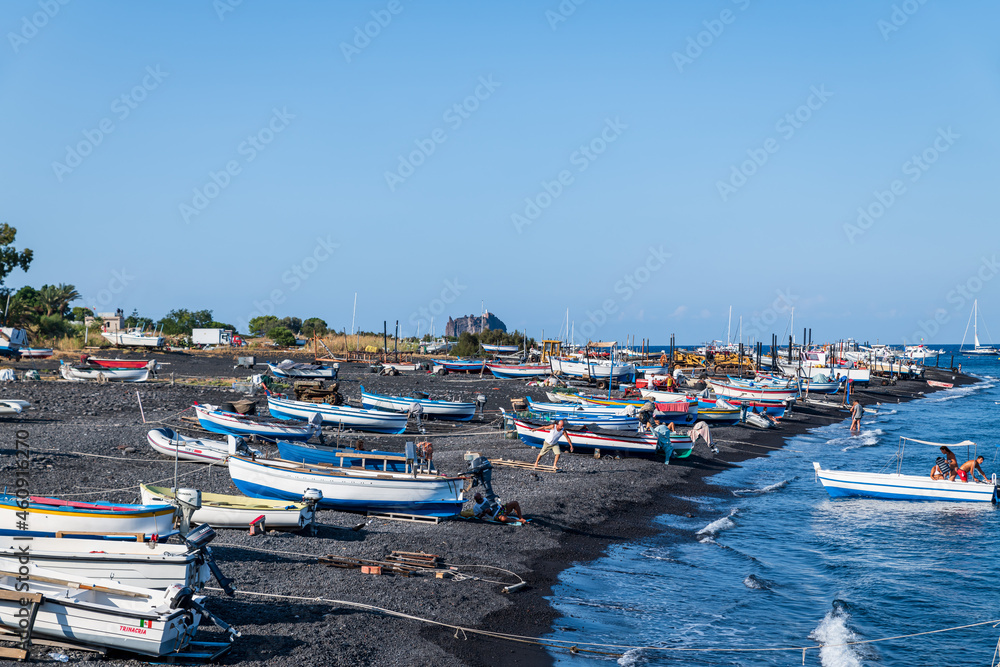 Stromboli island (Aeolian archipelago), Lipari, Messina, Sicily, Italy, 08.21.2021: view of the village   with many boats on the black lava beach.