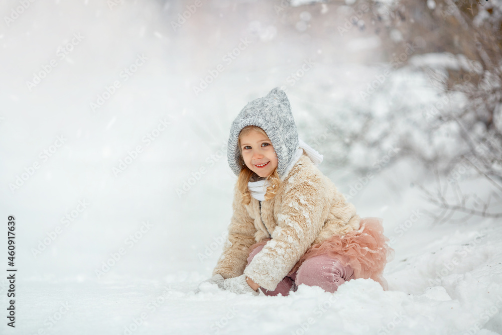 Cute little girl playing on snowy winter day in the park. Fantasy background. Cute little girl playing on snowy winter day in the park. Fantasy background.