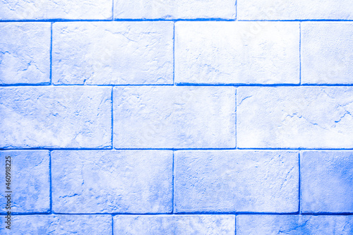 The wall is made of blue stone blocks with scuffs and damage. Cool, blue background with brick texture. 