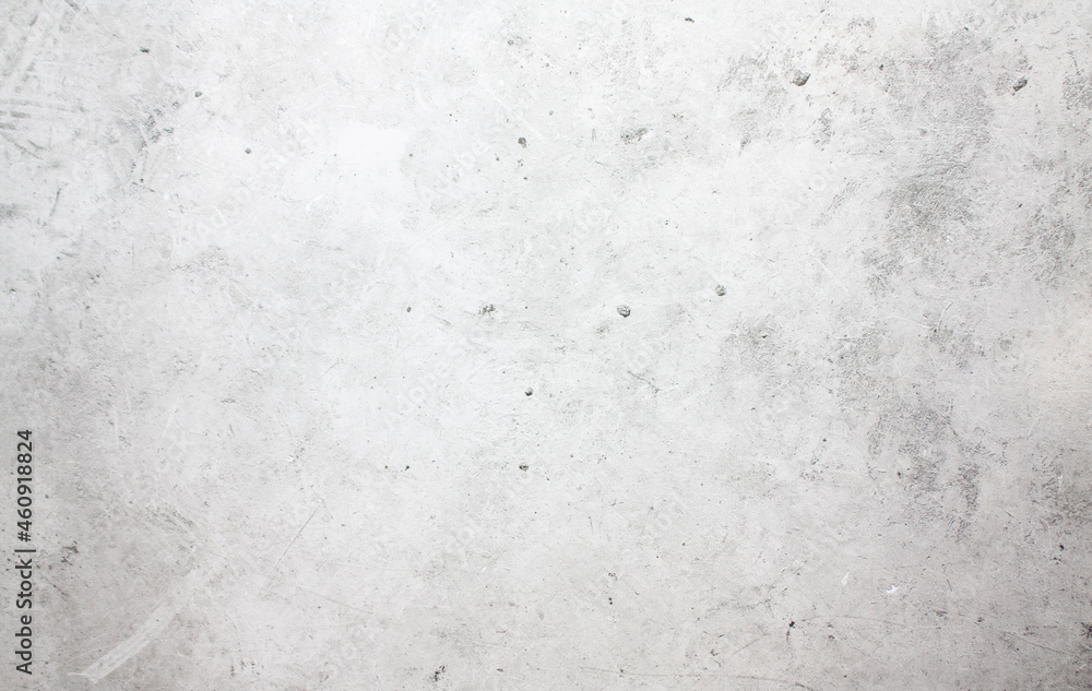 A concrete wall with dots and scuffs of light gray color. Light gray background with cement texture.
