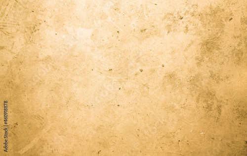 A concrete wall with dots and scuffs of yellowed color. Yellow background with cement texture. 