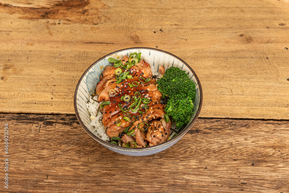 Bowl with fried chicken fillet with teriyaki sauce, sesame and poppy seeds, white rice and broccoli cooked with fresh chives Bowl with fried chicken fillet with teriyaki sauce, sesame and poppy seeds, white rice and broccoli cooked with fresh chives