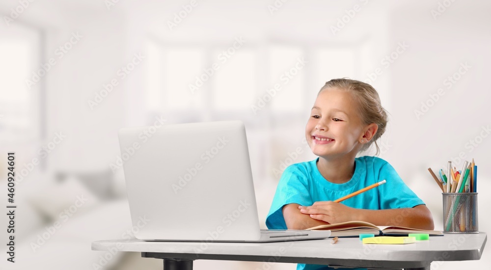 Happy cute schoolgirl drawing picture at home
