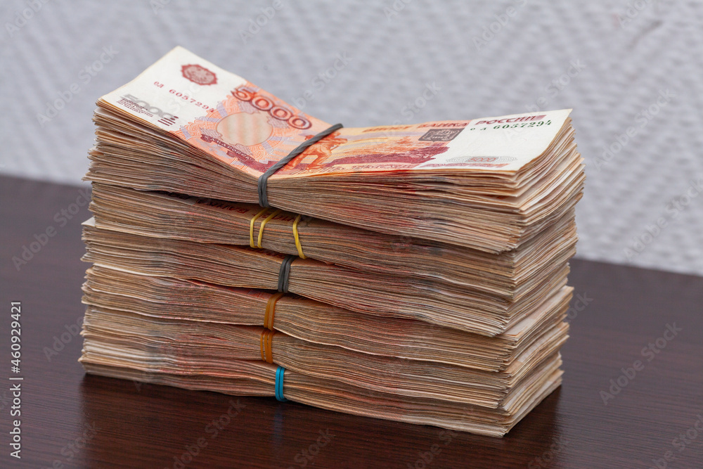 A stack of banknotes with a denomination of five thousand rubles lies on the table - obrazy, fototapety, plakaty 