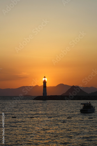 Seascape at sunshine. Lighthouse and sailings on the coast. Seaside town of Turgutreis and spectacular sunshine