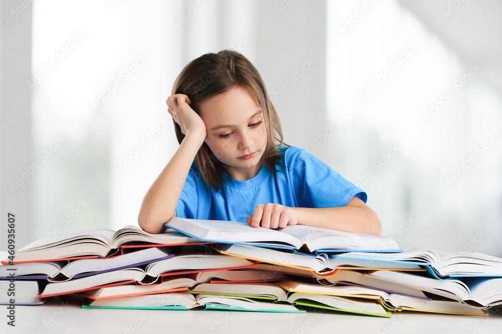 Happy cute schoolgirl studying at home