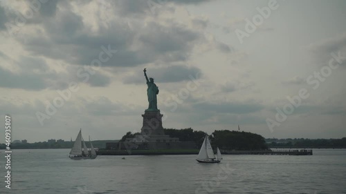 Statue of liberty and sailing boat at the sunset. Travel industry, democracy and freedom concept