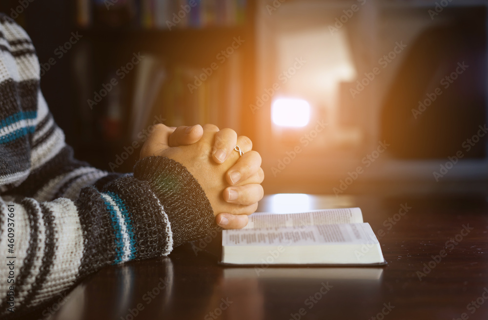 Christian hands while praying and worship for Jesus. christian people praying while hands worship over a Bible. learning religion. Selective focus on hands.