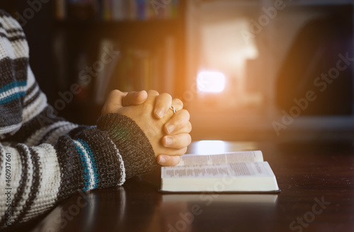 Christian hands while praying and worship for Jesus. christian people praying while hands worship over a Bible. learning religion. Selective focus on hands.