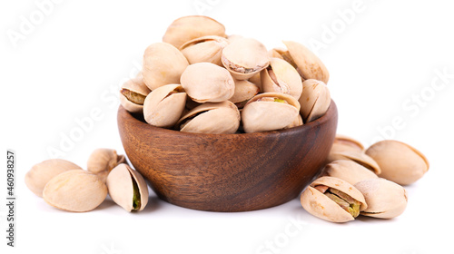 Pistachio nuts, isolated in wooden bowl, on white background. Salted roasted pistachios.