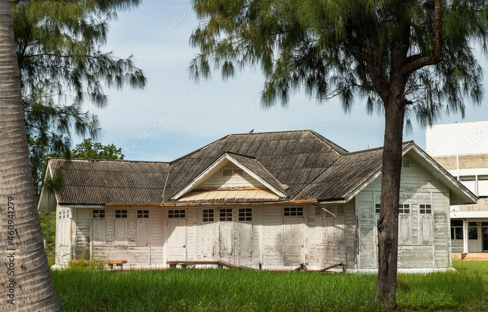 Phetchaburi, Thailand - Sep 18, 2021 : Beautiful old abandoned white wooden house on green grass. Selective focus.