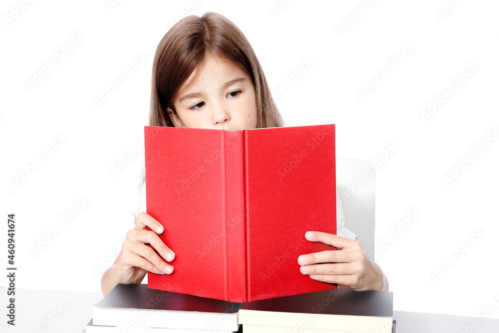 Young cute girl sitting at the table and reading a book Young cute girl sitting at the table and reading a book