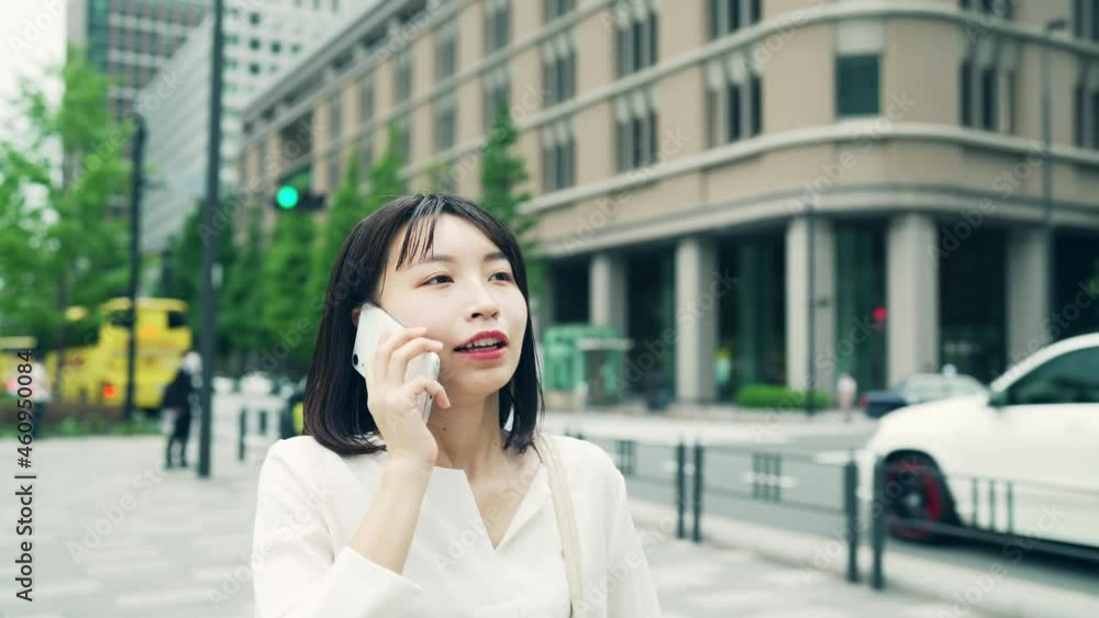 歩きながらスマホで通話する女性 歩きながらスマホで通話する女性
