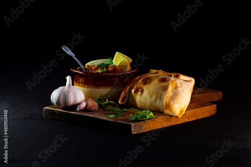 Traditional homemade empanadas and a bowl of pebre on a table, traditional food of national holidays in Chile  photo
