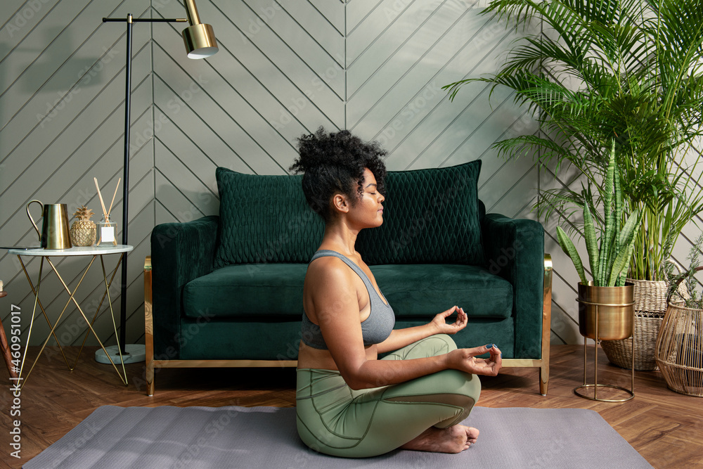 Healthy woman meditating in the living room Healthy woman meditating in the living room