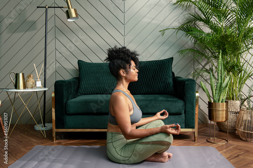 Healthy woman meditating in the living room