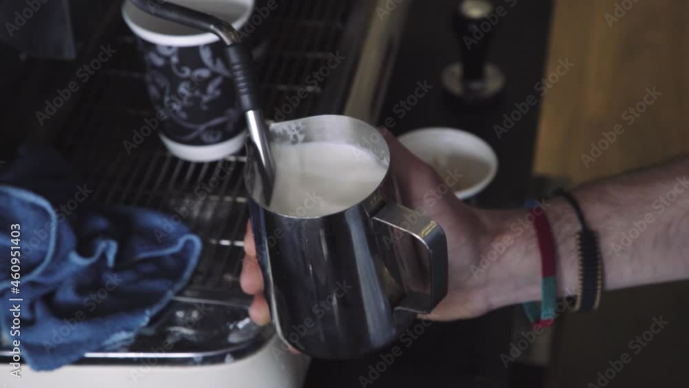 Frothing and heating milk in metal jug next to coffee machine, no steam Frothing and heating milk in metal jug next to coffee machine, no steam
