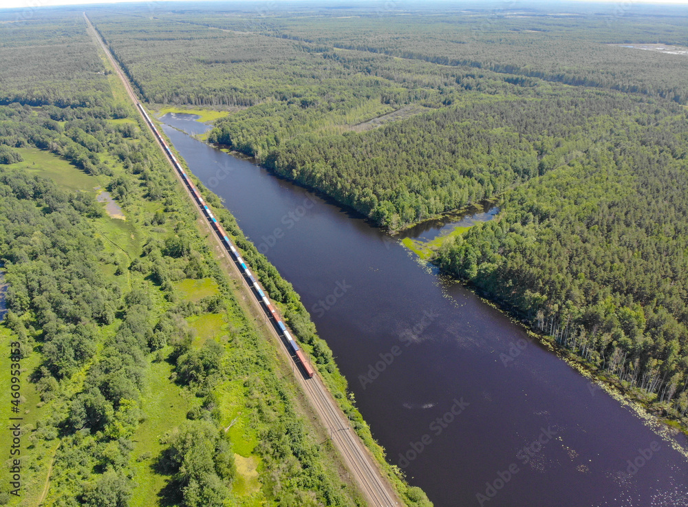 Aerial view of a freight train passing by a lake (Kotelnich, Kirov region, Russia)