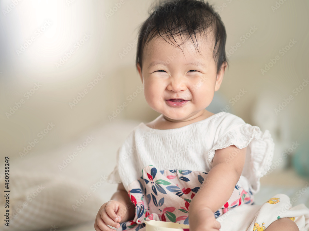 Close up adorable Asian cute infant baby sitting with happiness smiling , a sweet healthy baby infant concept Close up adorable Asian cute infant baby sitting with happiness smiling , a sweet healthy baby infant concept