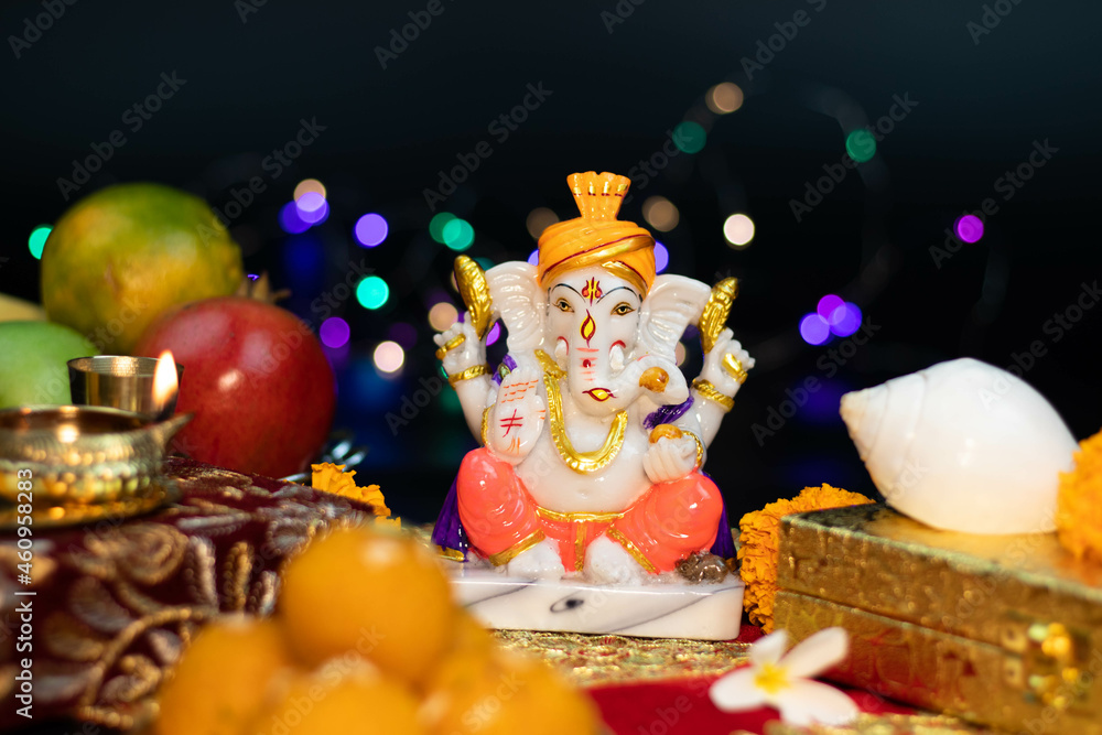Closeup Of Hindu God Ganesha Ganpati Bappa Morya In Sitting Pose On A Colorful Bokeh Effect Black Background. For Prayers On Diwali Puja New Year Deepawali Ganesh Chaturthi Or Shubh Deepavali Pooja