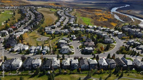 Aerial top down view of houses and streets in beautiful residential neighborhood in North America. Real estate, drone shots, sunset, sunlight. View from above on houses in Cochrane, Alberta, Canada.