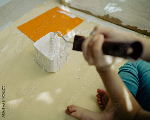 dipping roller paint into the paint container.