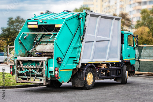 A garbage truck picks up garbage in a residential area. Separate collection and disposal of garbage. Garbage collection vehicle.