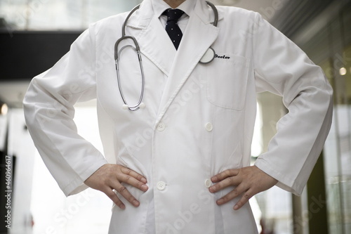 Confident doctor standing at hospital corridor