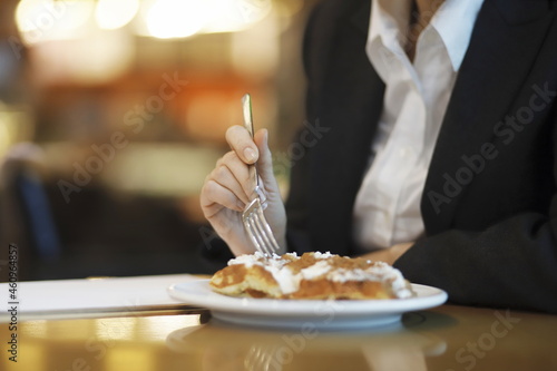 Businesswoman eating waffle in cafe