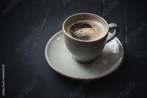 Mug of hot coffee on a wooden board