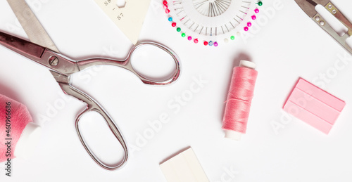 Sewing accessories concept. Hobby sewing with pink thread, scissors. . White background top view.